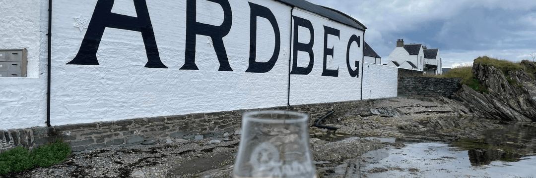 Kieliszek degustacyjny na tle destylarni Ardbeg